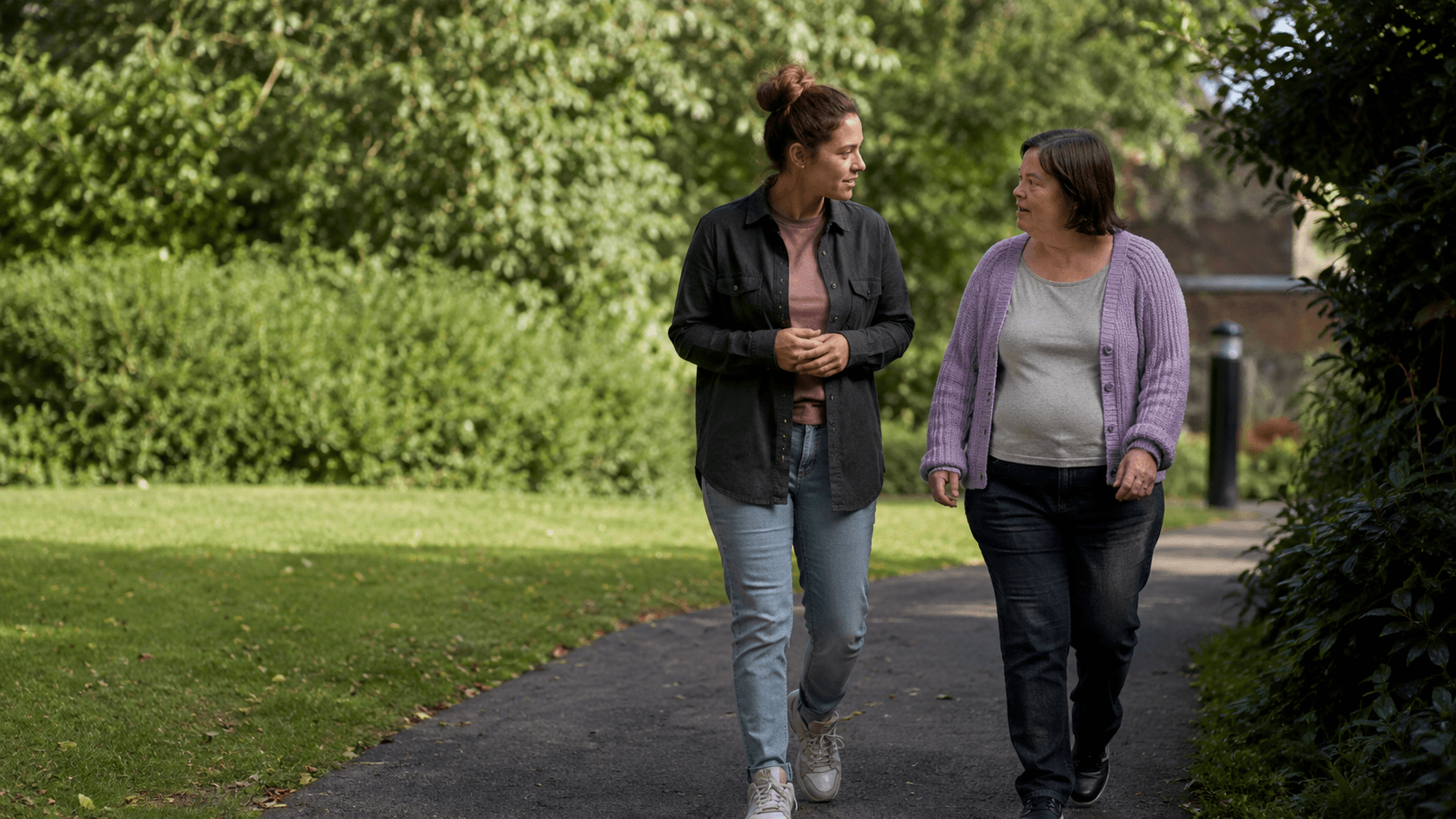 A support worker and an adult talking together during a walk.